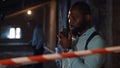 African-American policeman in talking on radio set at crime scene