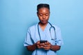 African american practitioner nurse holding smartphone