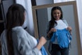 african american pregnant woman holding baby bodysuit and looking at reflection Royalty Free Stock Photo