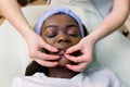 African-american pretty woman enjoying face massage at beauty salon, top view, copy space Royalty Free Stock Photo