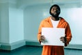 african american prisoner holding blank placard and looking