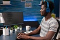 African american programmer with headphones writing program code