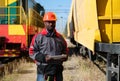 African american railway man with tablet computer at freight train terminal Royalty Free Stock Photo