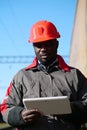 African american railway man with tablet computer at freight train terminal Royalty Free Stock Photo
