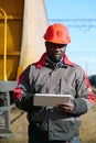 African american railway man with tablet computer at freight train terminal Royalty Free Stock Photo