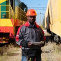 African american railway man with tablet computer at freight train terminal Royalty Free Stock Photo