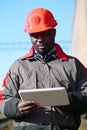 African american railway man with tablet computer at freight train terminal