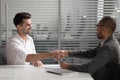 African American recruiter shaking hand of Caucasian candidate at interview Royalty Free Stock Photo