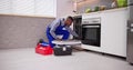 African American Repairman Fixing Dishwasher Appliance Royalty Free Stock Photo