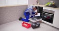 African American Repairman Fixing Dishwasher Appliance Royalty Free Stock Photo