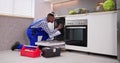 African American Repairman Fixing Dishwasher Appliance Royalty Free Stock Photo
