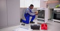 African American Repairman Fixing Dishwasher Appliance Royalty Free Stock Photo