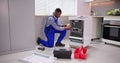 African American Repairman Fixing Dishwasher Appliance Royalty Free Stock Photo