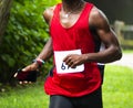 African American runner running a 10K trail race in the woods