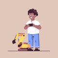 african american schoolboy playing with radio controlled tractor toy smiling boy having fun