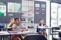 African american schoolboy working at desk in class with diverse pupils, copy space