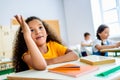 african american schoolgirl raising hand to answer teachers question Royalty Free Stock Photo