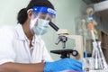 African american Scientist man look into Microscope research in science laboratory. Asian biochemistry scientist using microscope Royalty Free Stock Photo