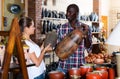 African-american seller offers woman traditional handmade african pottery