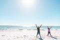 African american senior couple with arms raised exercising at beach against sea and clear blue sky Royalty Free Stock Photo