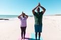African american senior couple meditating in mountain pose at beach against clear sky Royalty Free Stock Photo