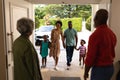 African american senior couple welcoming their family while standing on the front door at home Royalty Free Stock Photo
