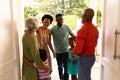 African american senior couple welcoming their family while standing on the front door at home Royalty Free Stock Photo