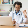 African american senior doctor explaining therapy at video chat Royalty Free Stock Photo