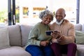 African american senior man with woman watching video over digital tablet on sofa in nursing home Royalty Free Stock Photo