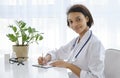 African american smiling female doctor sitting at the table in the medical office and working on the computer Royalty Free Stock Photo