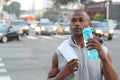 African American Sport man drinking water bottle in New York City. Male runner sweaty and thirsty after run