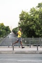 African American sportsman jogging across the bridge with a highway underneath in the city outdoors Royalty Free Stock Photo