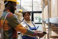 African american storehouse manager looking at worker scanning parcels