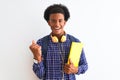 African american student man wearing headphones backpack over isolated white background screaming proud and celebrating victory Royalty Free Stock Photo