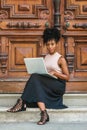 African American Student studying in New York, with afro hairstyle, wearing sleeveless light color top, black skit, strappy Royalty Free Stock Photo