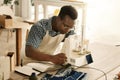 african american tailor sewing a piece of denim. Young designer using his sewing machine. Serious tailor stitching a Royalty Free Stock Photo