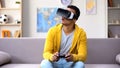 African-American teen boy with joystick playing video game in VR headset, future