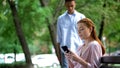 African american teen boy noticing girlfriend chatting smartphone, jealousy