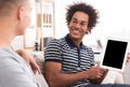 African-american teen boy showing tablet with blank screen Royalty Free Stock Photo