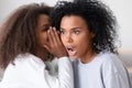 African american teen daughter whispering in mom ear telling secret Royalty Free Stock Photo