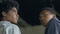 African-American teen hooligans preparing for illegal deal, crime, back-view