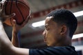 African American teenage boy concentrated on playing basketball