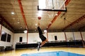 African American teenage boy playing basketball alone on the court