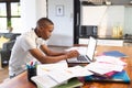 African american teenage boy using computer and doing lessons at home