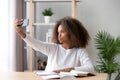 African American teenage girl taking selfie during homework preparation Royalty Free Stock Photo