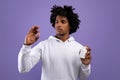 African American teenager holding jar and pill over violet studio background. Health care, treatment of coronavirus