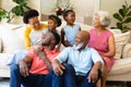 African american three generation family smiling looking at each other sitting on couch at home Royalty Free Stock Photo