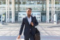 African american tourist businessman walks public transport building with luggage background, rear back view Man in formal suit Royalty Free Stock Photo