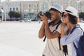 African-american tourist couple taking photos on camera on street Royalty Free Stock Photo