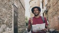 African american tourist man walking and watching paper city map to find directions to famous place Royalty Free Stock Photo